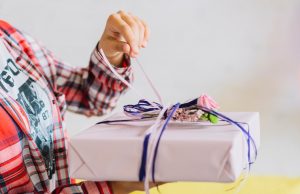 close-up-girl-s-hand-unwrapping-birthday-gift_23-2147950788