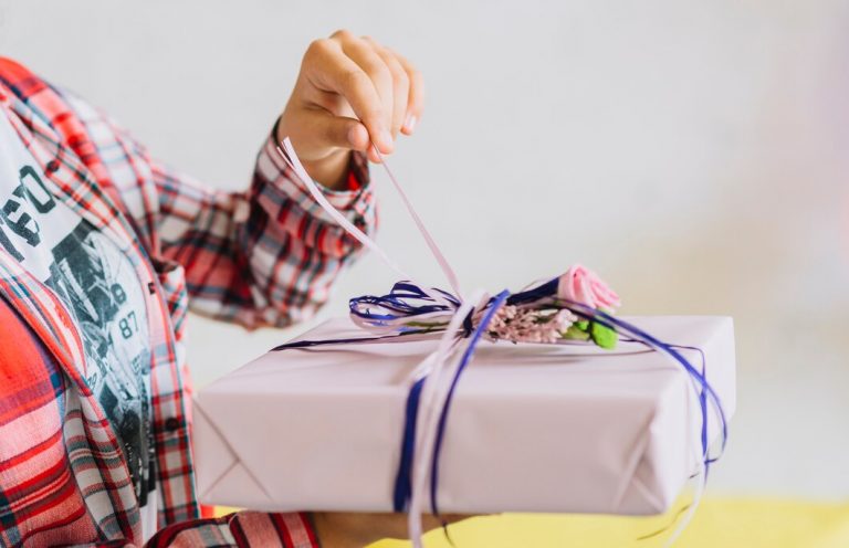 close-up-girl-s-hand-unwrapping-birthday-gift_23-2147950788